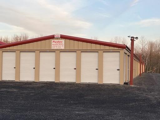 Row of drive-up storage units with white doors at Ryder Storage